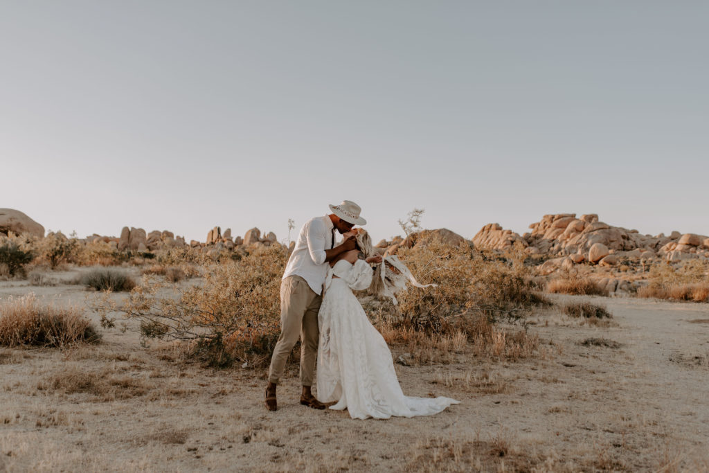 Bride and groom sharing a passionate kiss in the middle of Joshua Tree National Park during their elopement shoot with Off Path Photography