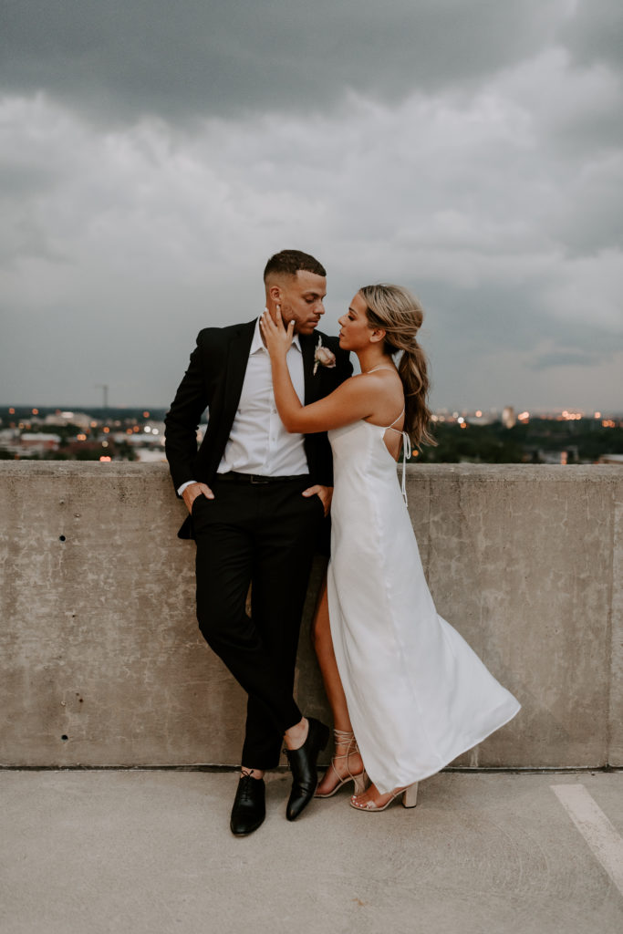 Bride places her hands on the groom's cheek as the look at each other during their rooftop wedding shoot
