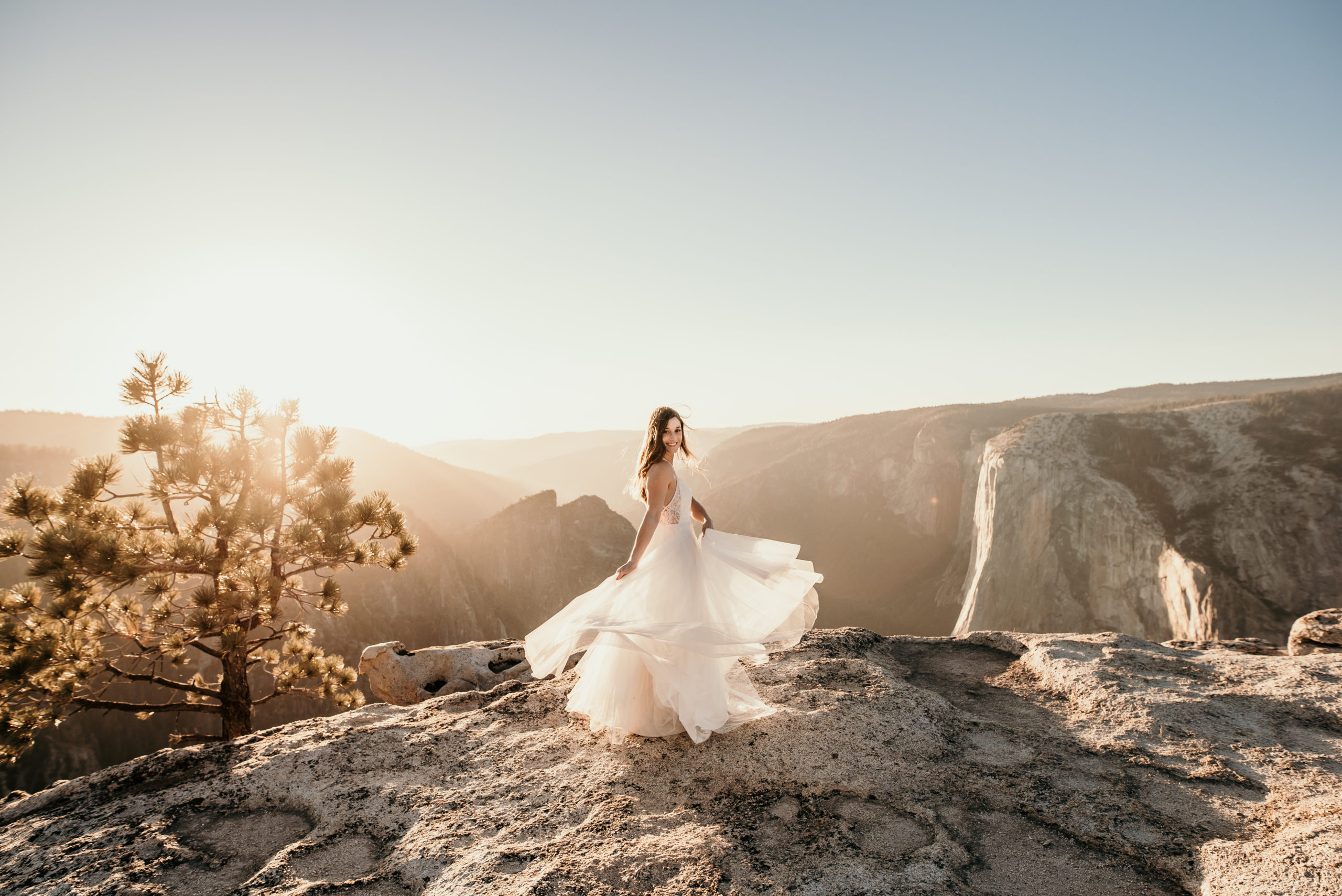 Bride twirling on the top of a mountain top in her wedding gown photographed by Off Path Photo
