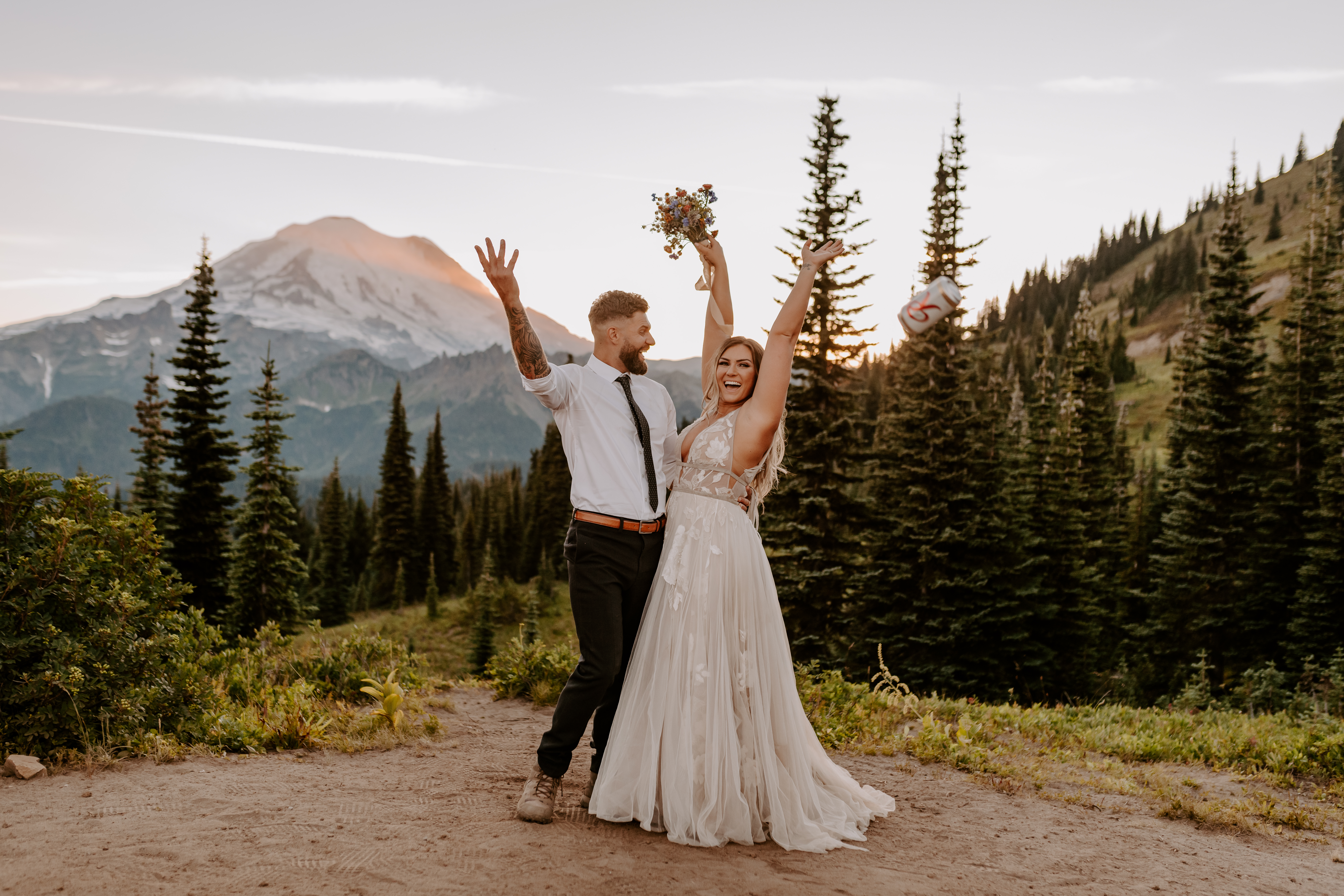 Couple throwing up cans of coke and flowers during their elopement shoot in Idaho, captured by Off Path Photography