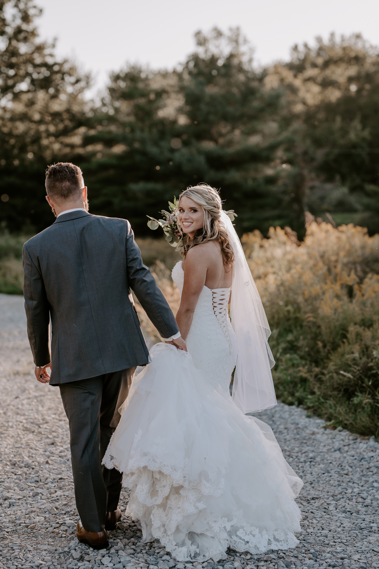 Bride and groom walking along a rocky path in Lake County during their wedding shoot
